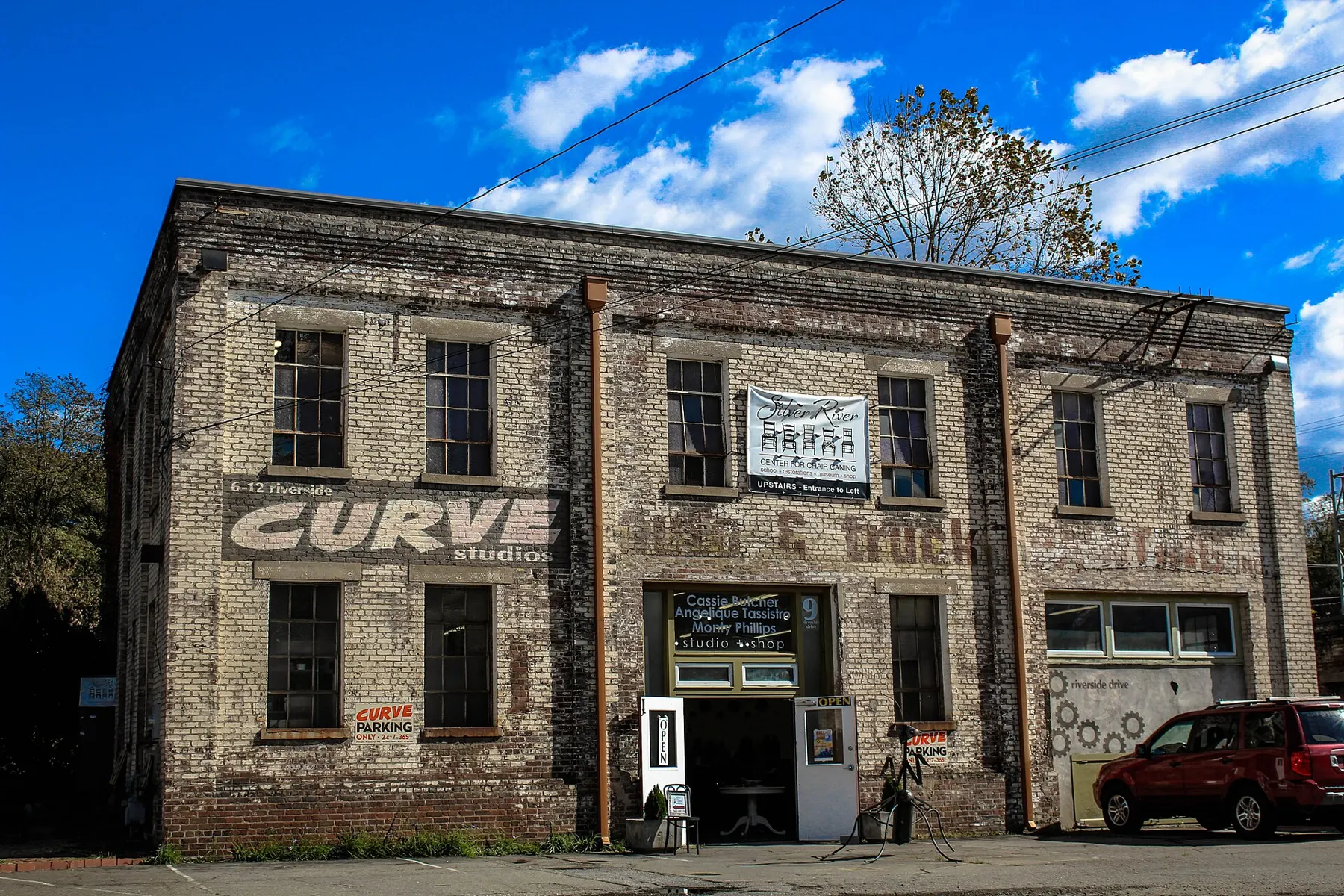 An old two-story brick industrial building in the River Arts District with a Curve studios sign