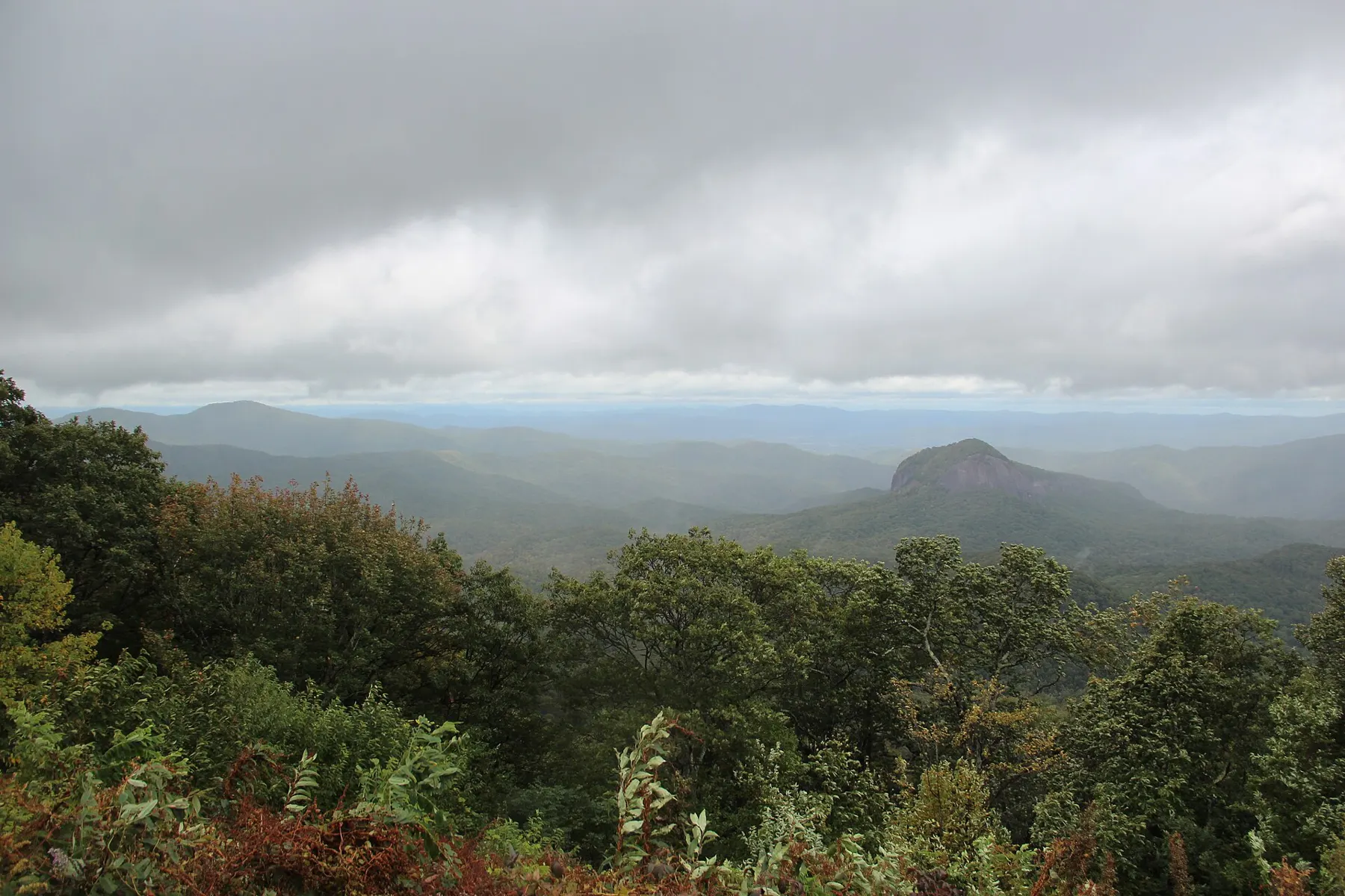 Vista nublada desde un mirador de la Blue Ridge Parkway hacia las montañas y Looking Glass Rock